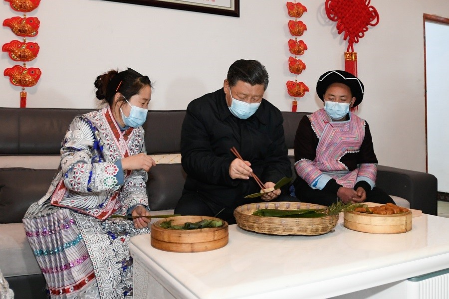 2021年2月3日下午，習(xí)近平在貴州畢節(jié)市黔西縣新仁苗族鄉(xiāng)化屋村苗族村民趙玉學(xué)家，同一家人邊聊家常邊制作當(dāng)?shù)貍鹘y(tǒng)節(jié)日食品黃粑。新華社記者 李學(xué)仁 攝