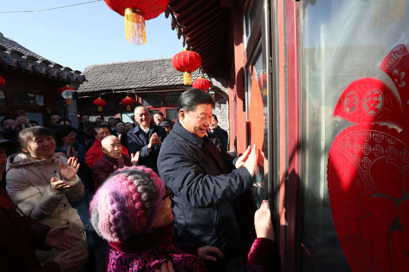 2019年2月1日上午，習(xí)近平在北京前門東區(qū)草廠四條胡同32號(hào)院，高興地拿起一幅“?！弊?，親自貼到門上，給這里的老街坊們拜年。新華社記者 鞠鵬 攝