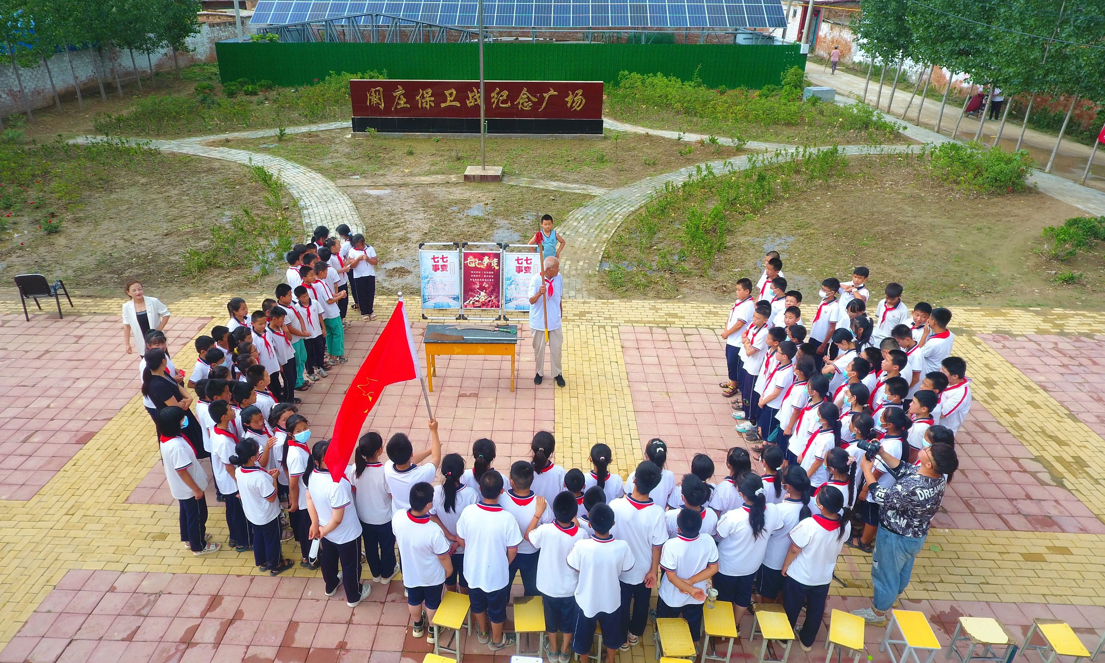 2022年7月6日，山東省聊城市，在茌平區(qū)菜屯鎮(zhèn)闞莊村的闞莊保衛(wèi)戰(zhàn)紀(jì)念廣場(chǎng)，闞莊保衛(wèi)戰(zhàn)親歷者王光木老人，為小學(xué)生們講述抗戰(zhàn)故事，展示大刀、長(zhǎng)矛。