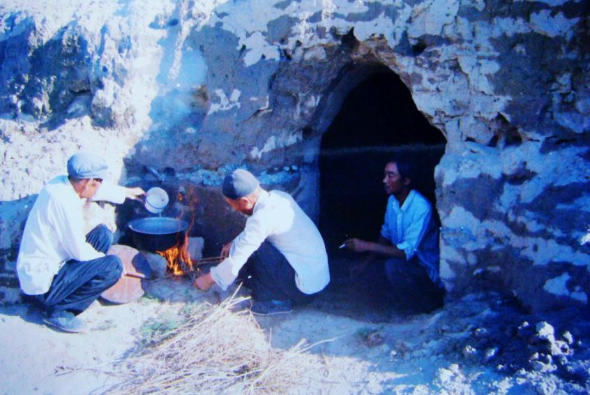 1983年，“六老漢”一代治沙人在“地窩子”生活做飯。新華社發(fā)（八步沙林場供圖）